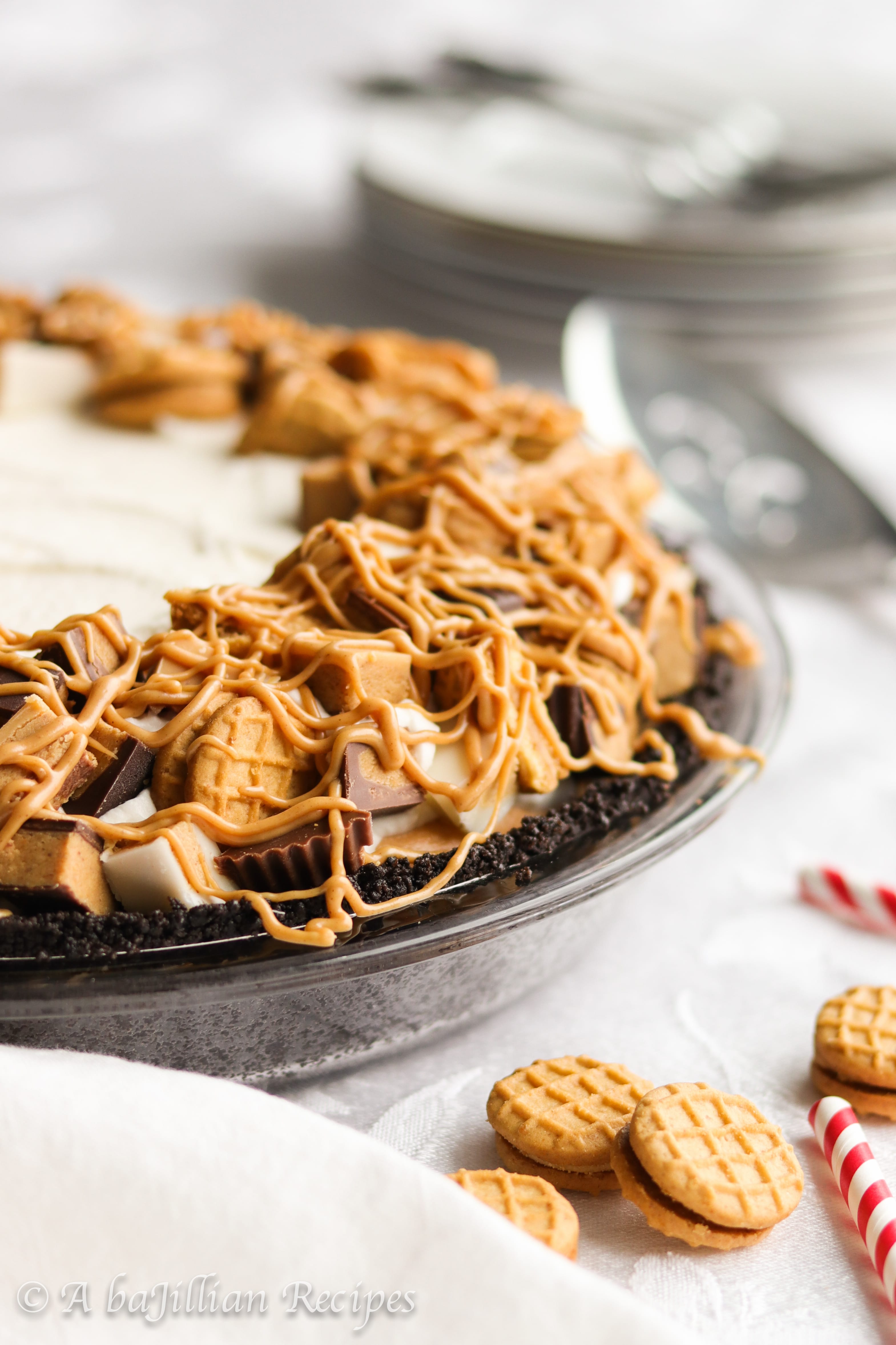 This no-bake pie features a Nutter Butter cookie truffle filling, peanut butterscotch cream filling, fluffy whipped cream, a generous crown of Reese's Cups, and a luscious peanut butter drizzle!